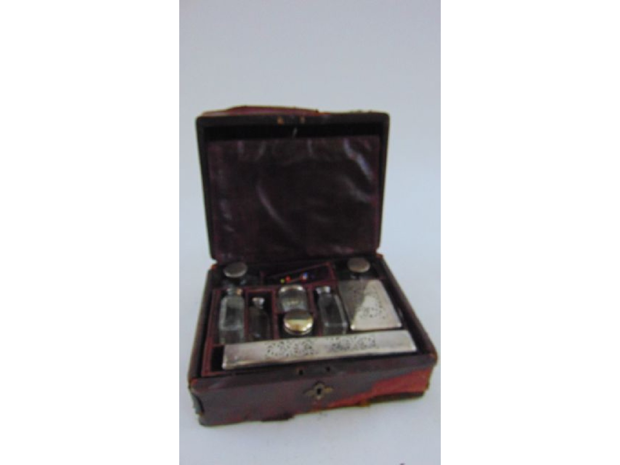 Appraisal: A Victorian maroon leather travelling box containing a collection of