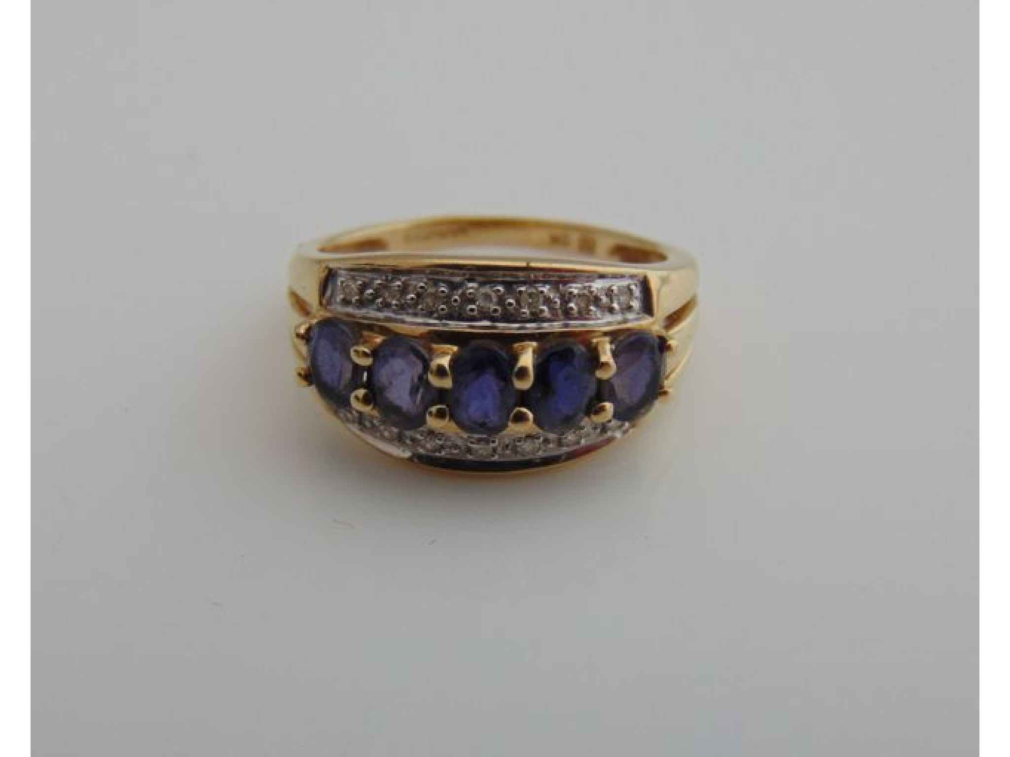 Appraisal: An iolite and diamond ring centred with five oval mixed-cut