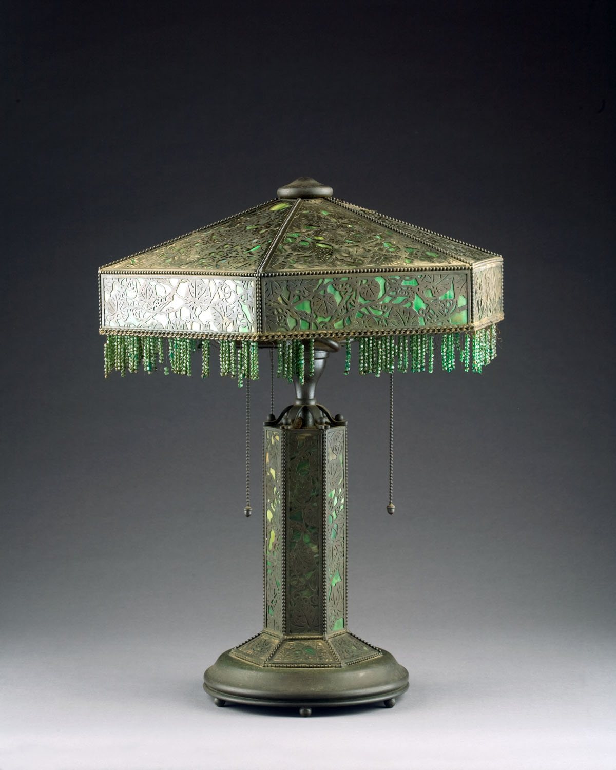 Appraisal: AMERICAN ARTS CRAFTS PATINATED-METAL AND SLAG GLASS 'GRAPEVINE' PATTERN LAMP