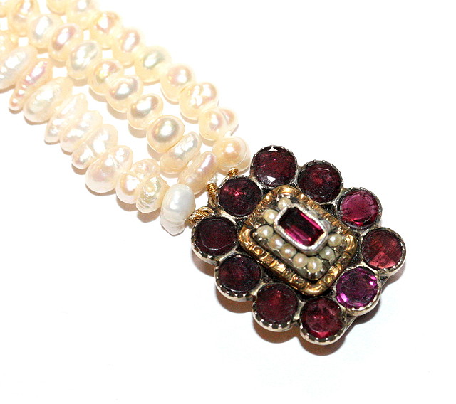 Appraisal: A TRIPLE ROW FRESH WATER PEARL NECKLACE with garnet and