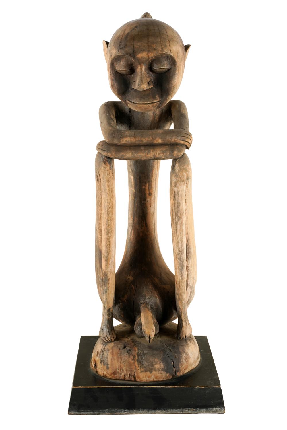 Appraisal: CARVED WOOD FIGURE OF A SEATED MANwith a bird perched