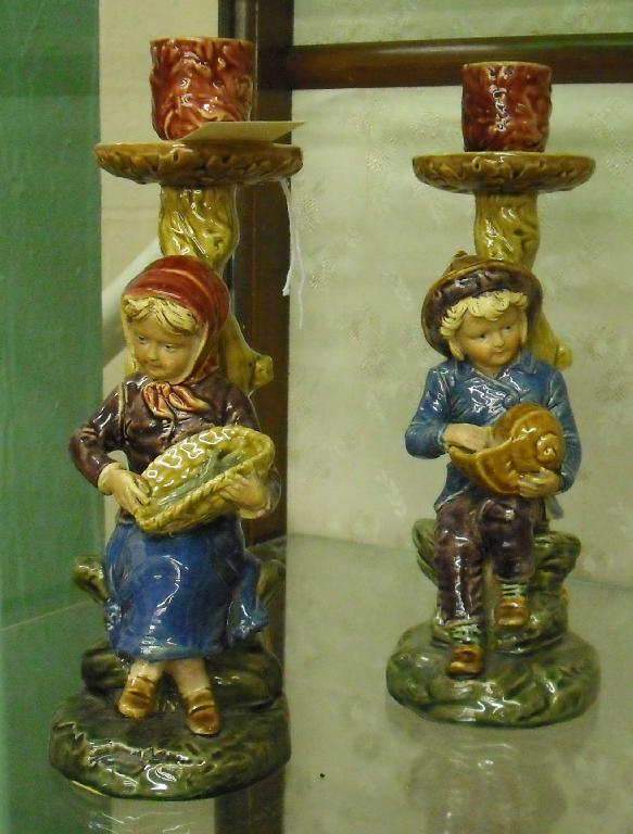 Appraisal: Pair of Austrian pottery figural candlesticks depicting a seated girl