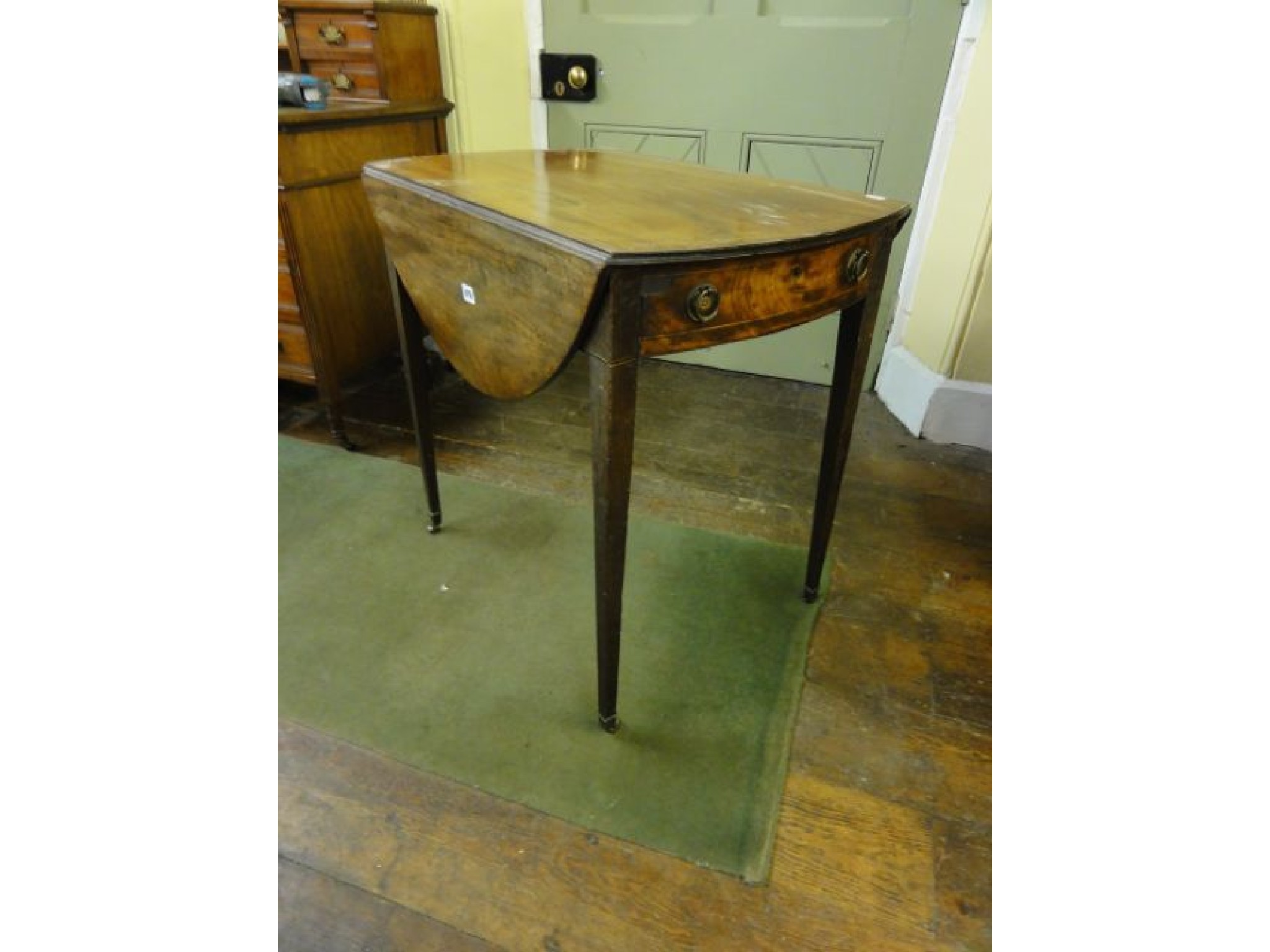 Appraisal: A Georgian III mahogany Pembroke table of oval form enclosing