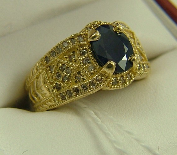 Appraisal: SAPPHIRE DIAMOND AND FOURTEEN KARAT GOLD RING centering an oval-cut