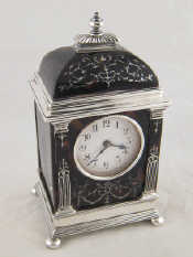 Appraisal: A silver mantel clock with domed top and silver inlaid