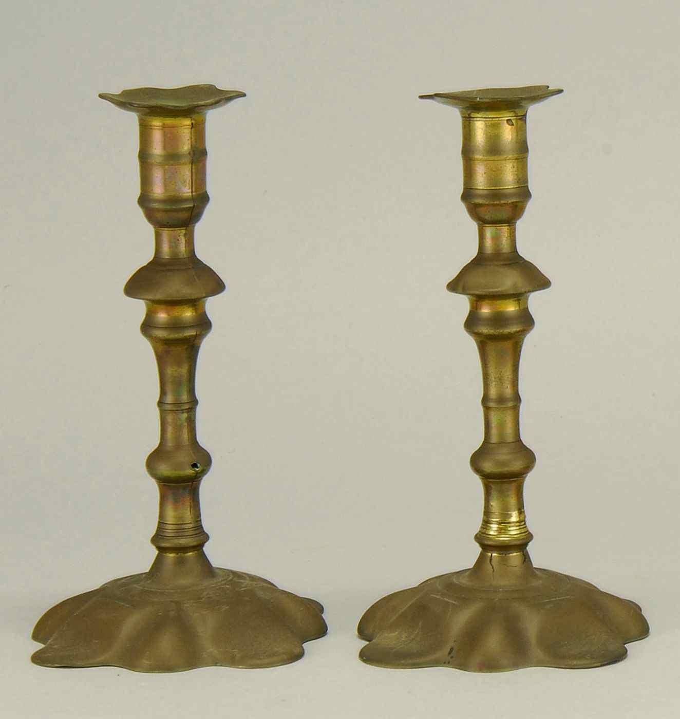 Appraisal: PAIR OF ANTIQUE ENGLISH BRASS CANDLESTICKS th CenturyWith petal-form base