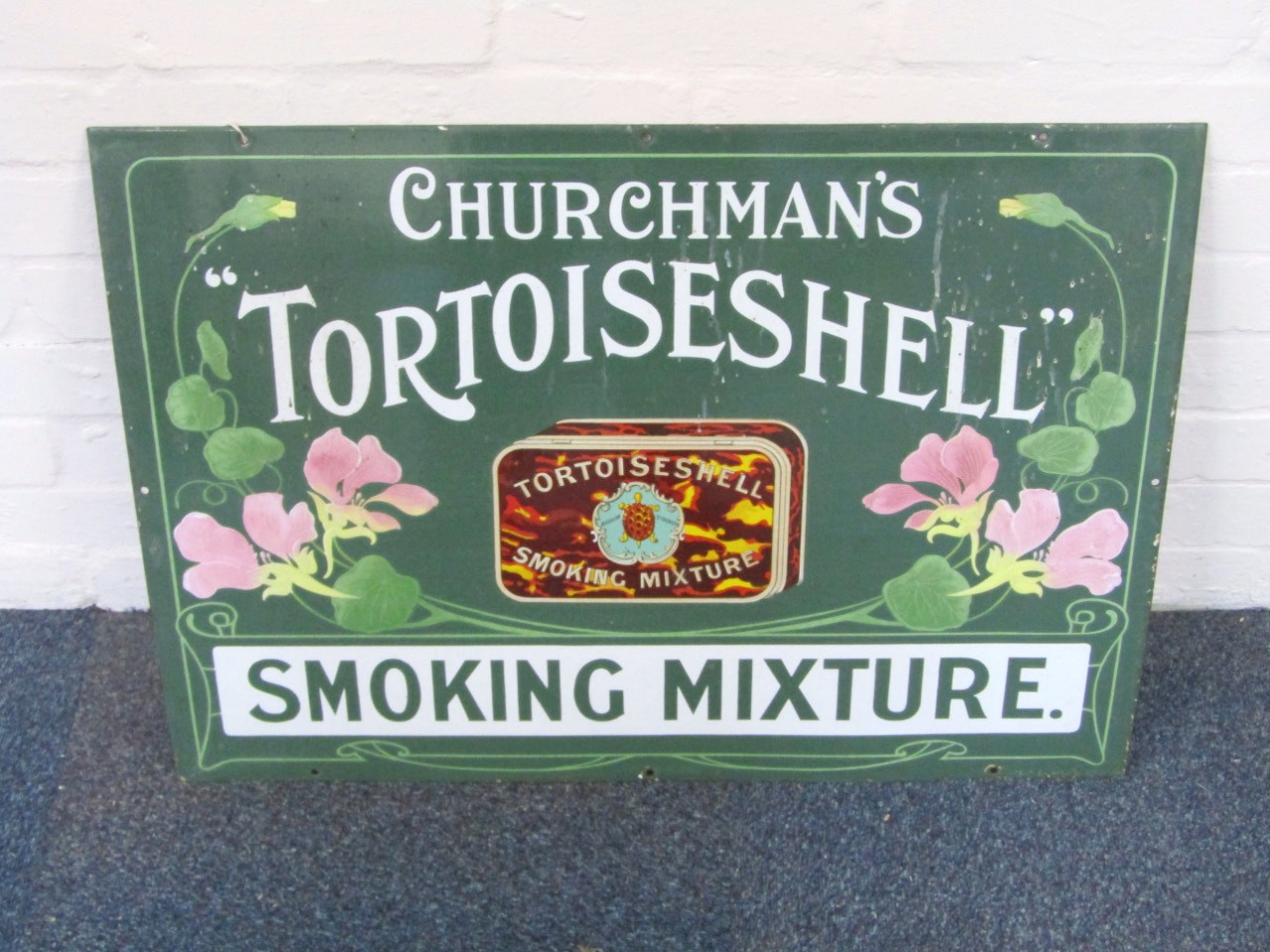 Appraisal: A Churchman's Tortoiseshell Smoking Mixture enamel sign with Art Nouveau