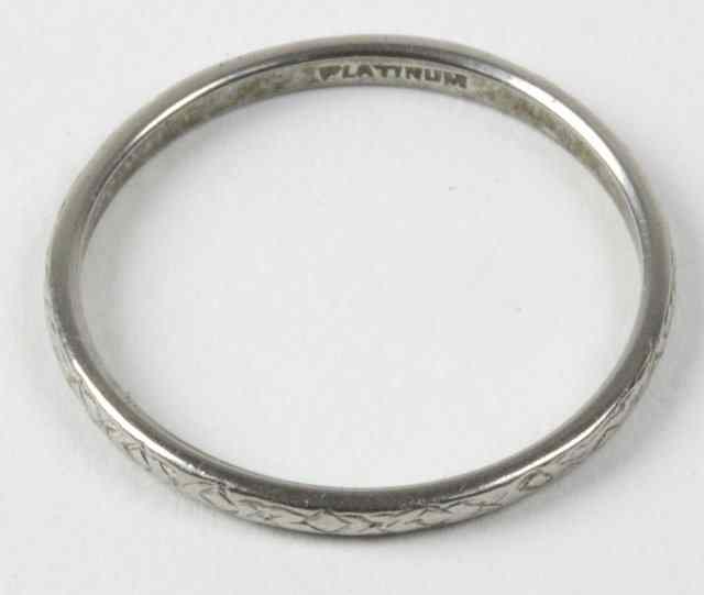 Appraisal: A platinum wedding band chased with a geometric pattern stamped