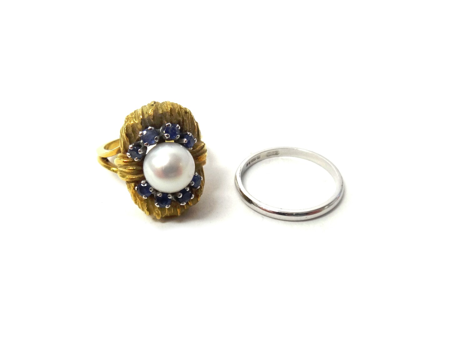 Appraisal: A gold ring mounted with a cultured pearl at the