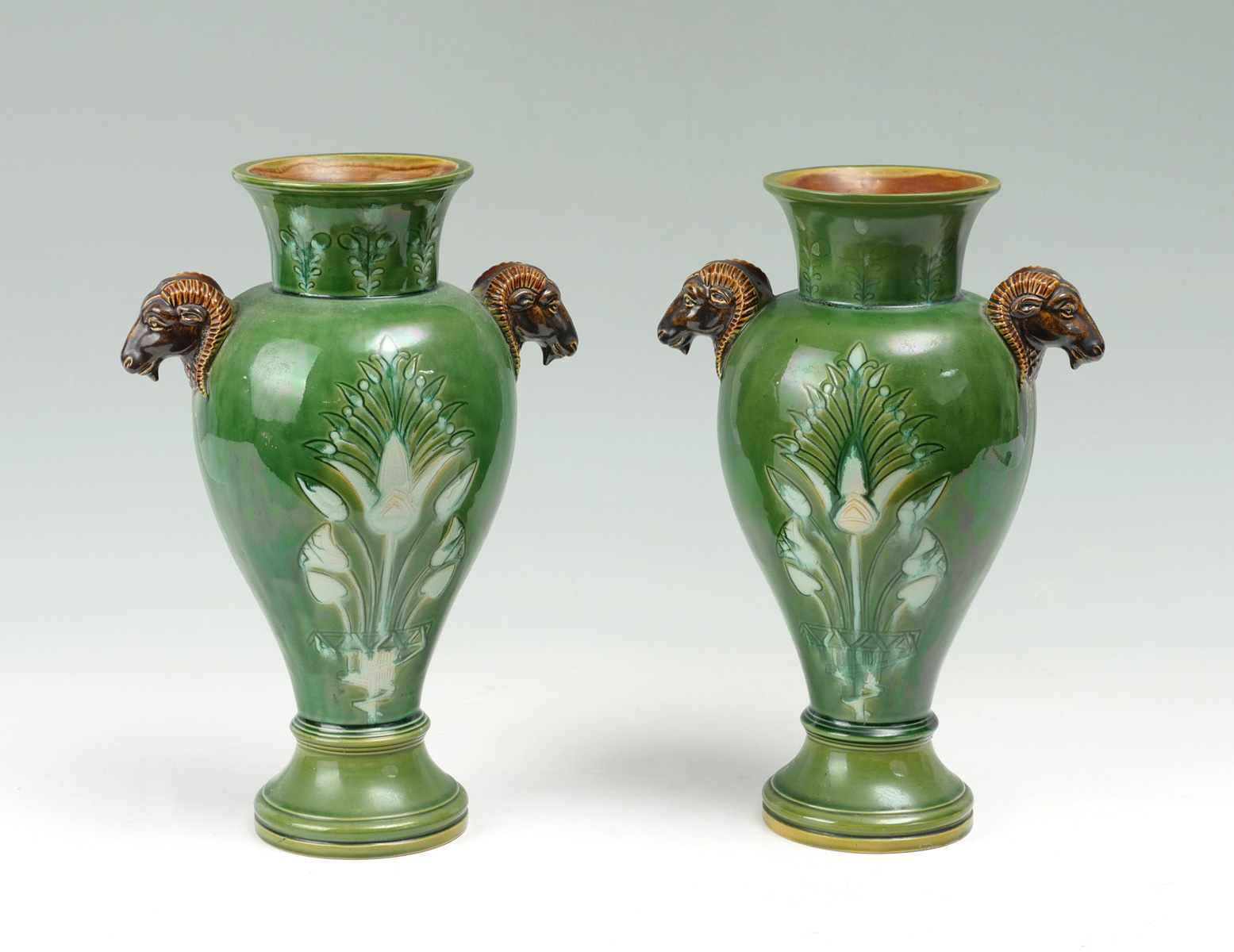 Appraisal: PAIR OF RAMS HEAD MAJOLICA VASES green iridescent majolica vases