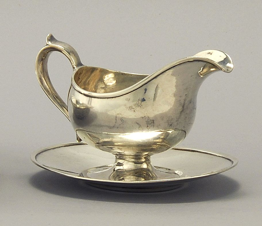 Appraisal: HAND-HAMMERED STERLING SILVER GRAVY BOAT AND TRAY BY ARTHUR STONE