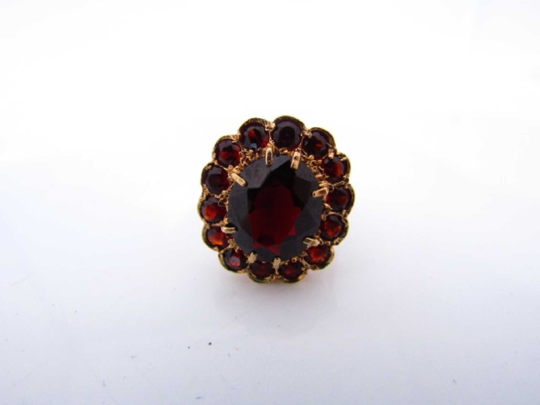 Appraisal: A gem-set ring centred with an oval mixed-cut untested garnet