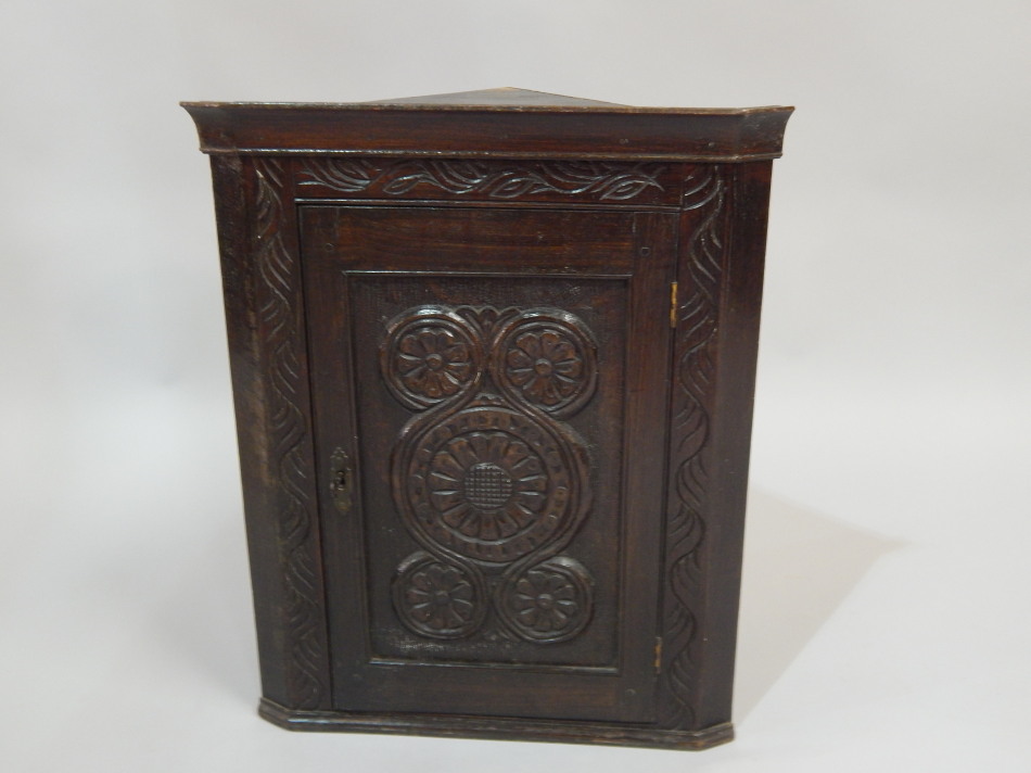 Appraisal: An early thC dark oak small hanging corner cabinet with