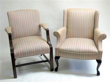 Appraisal: Two English upholstered armchairs The enclosed armchair with scrolled arms