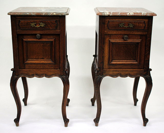 Appraisal: A PAIR OF CONTINENTAL OAK BEDSIDE CABINETS with square marble