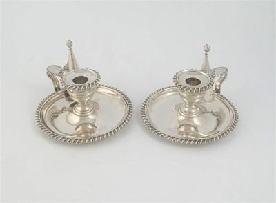 Appraisal: A pair of Victorian circular chambersticks with gadrooned borders detachable