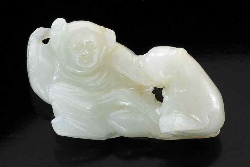 Appraisal: Chinese Qing carved white jade boyplaying with a dog the