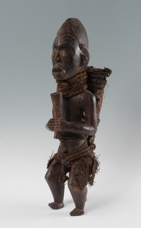 Appraisal: YORUBA CARVED AFRICAN FIGURE WITH BASKET Standing figure with woven