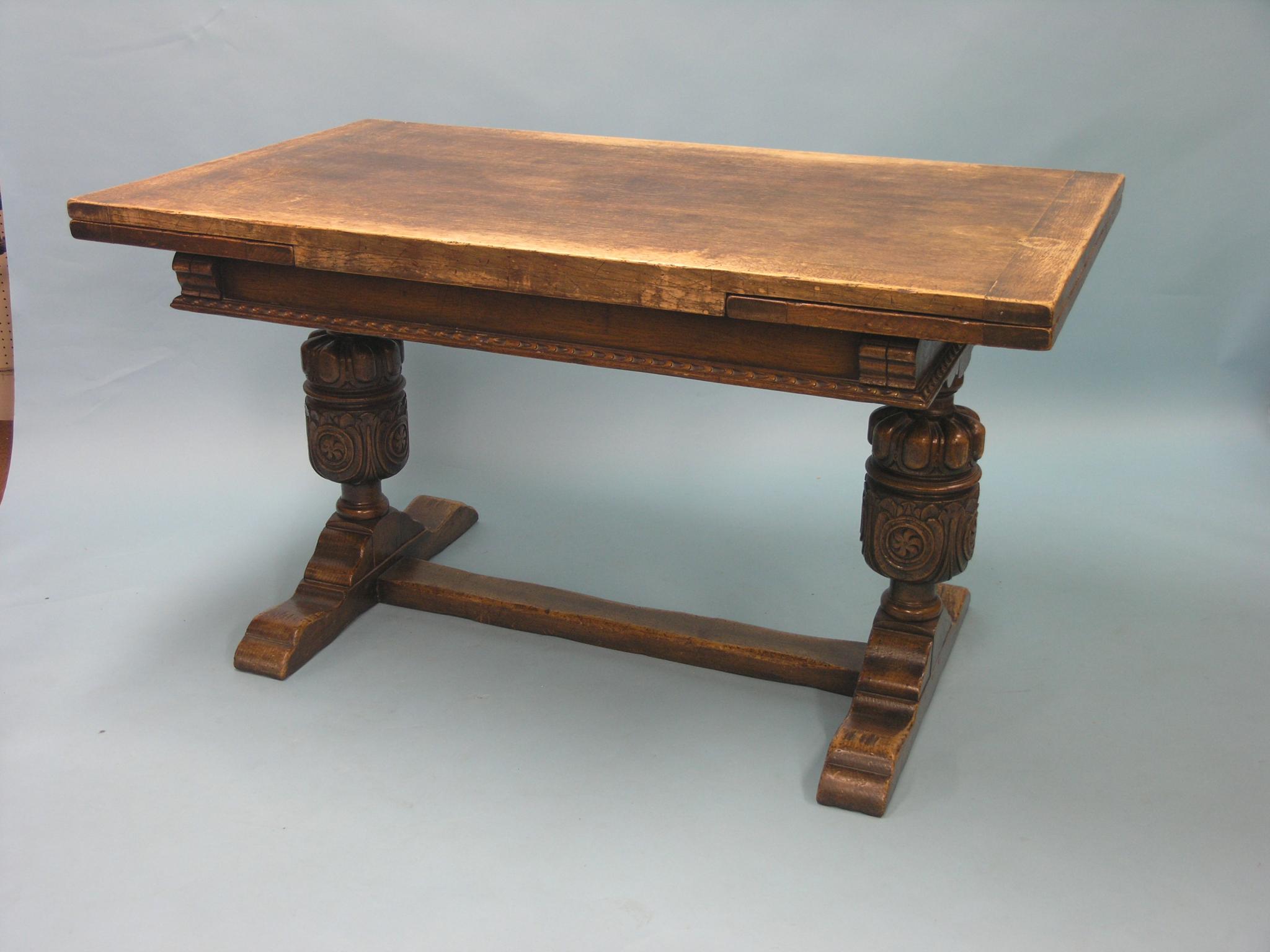 Appraisal: A solid dark oak draw-leaf dining table bulbous-turned end supports