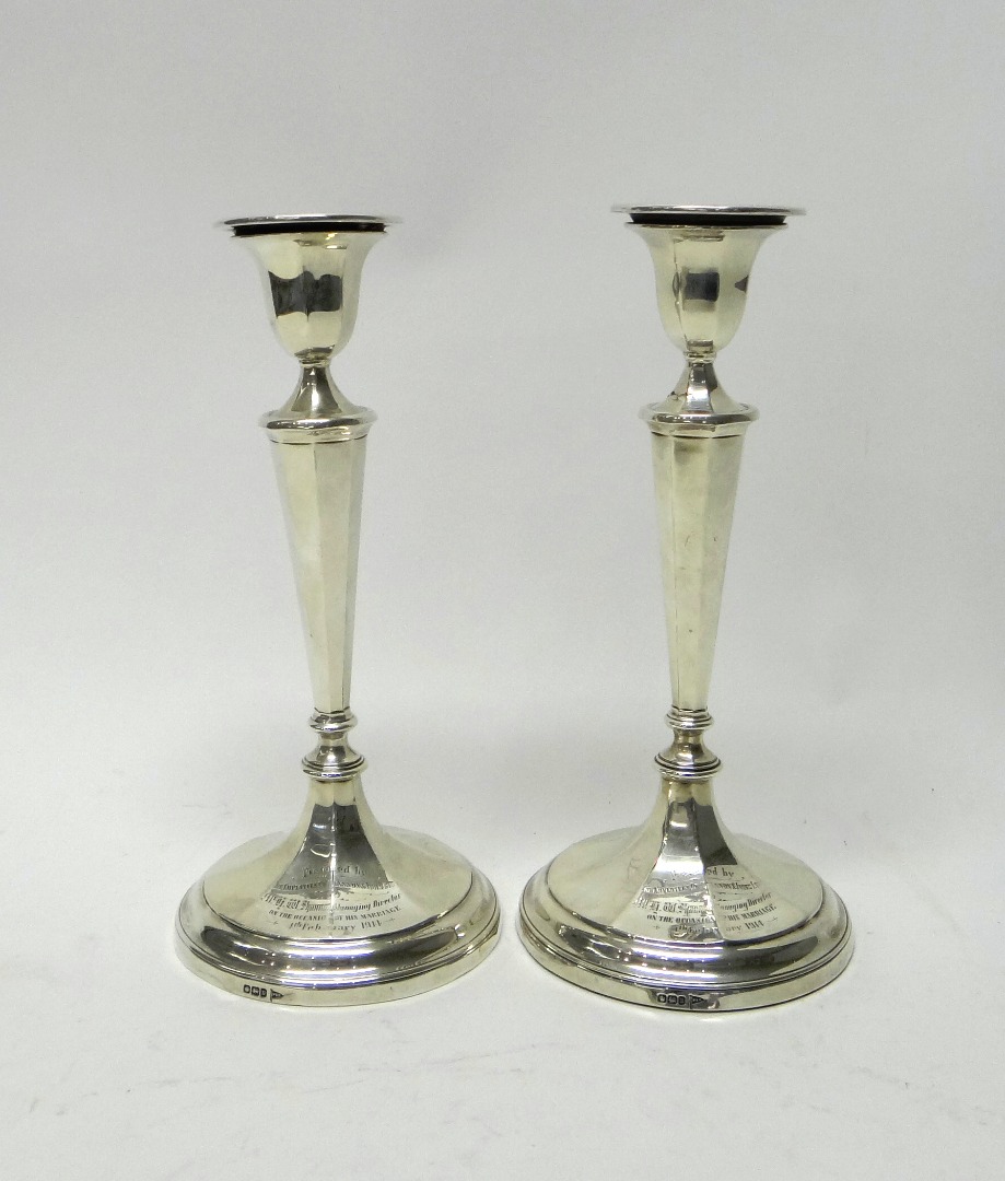 Appraisal: A pair of silver table candlesticks each having a tapered