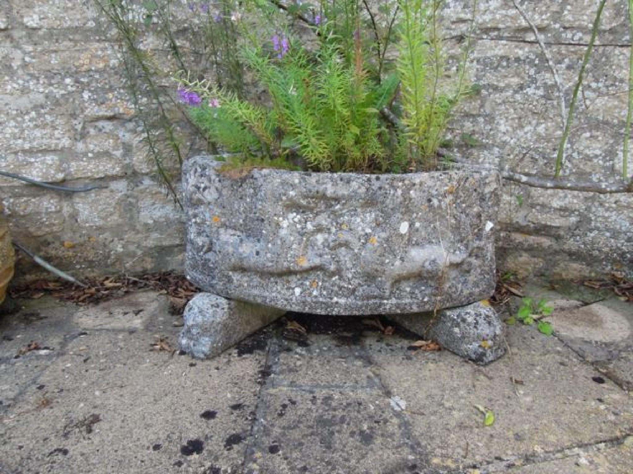 Appraisal: A reconstituted weathered corner trough with ancient horse detail on