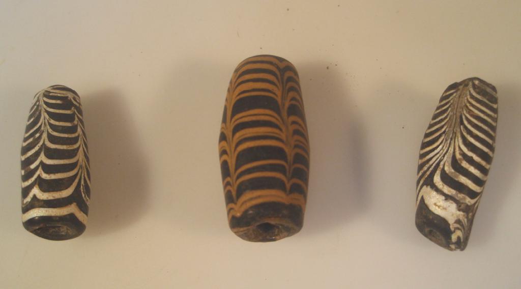 Appraisal: Three rod-formed cylindrical glass beads appearing black and decorated with