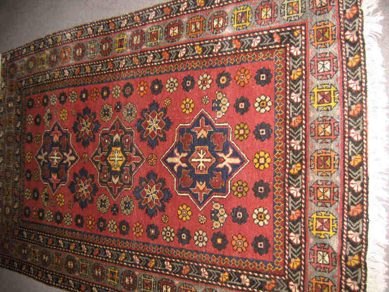 Appraisal: CAUCASIAN STYLE AREA RUG The salmon field of floral motifs