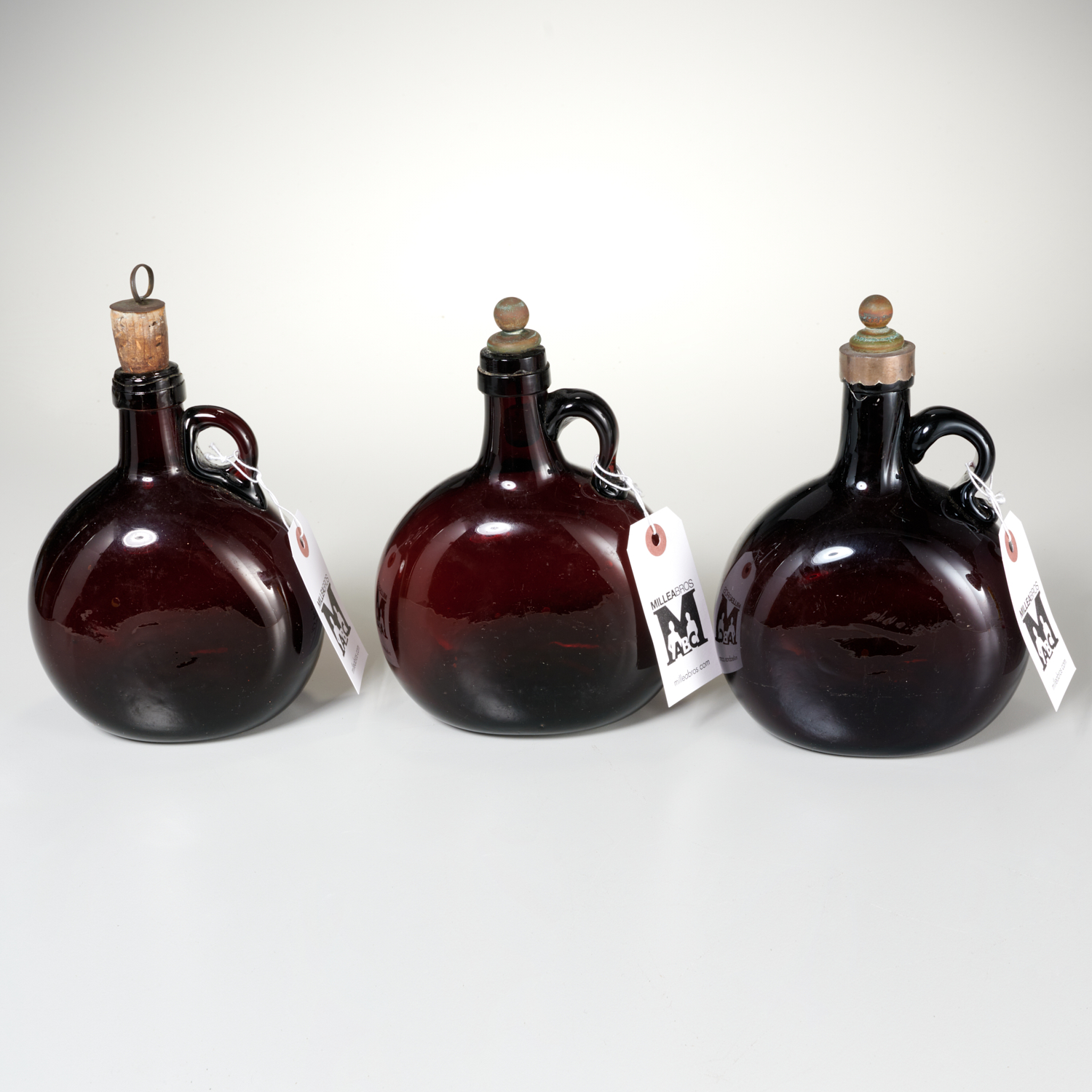 Appraisal: ANTIQUE ENGLISH BROWN GLASS DECANTERS th c each with rounded