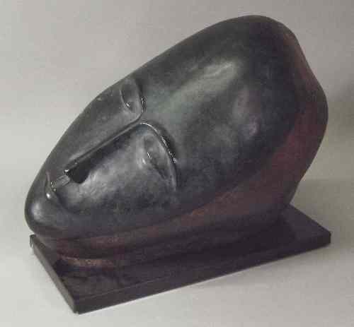 Appraisal: A large cast and patinated metal sculpture of a reclining