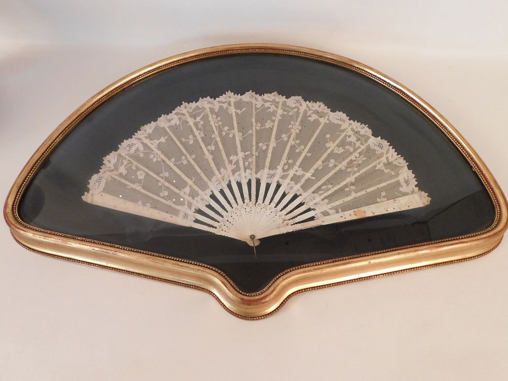 Appraisal: FRAMED BONE HAND FAN Antique lace and carved bone hand