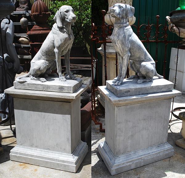 Appraisal: A PAIR OF COMPOSITE STONE HOUNDS ON PLINTHS the seated