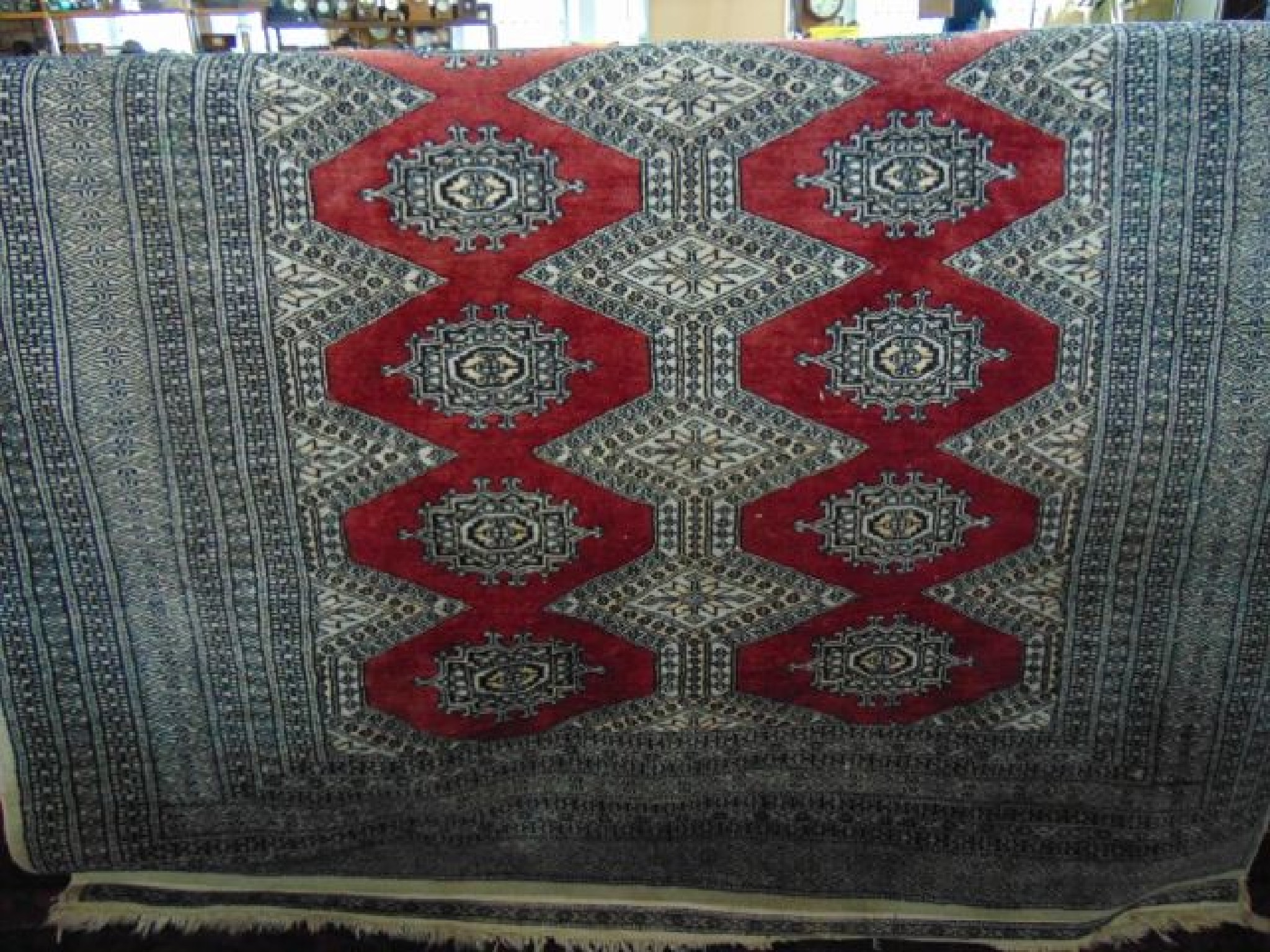 Appraisal: An Afghan rug with plum coloured ground geometric medallion and