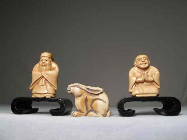 Appraisal: Three carved ivory netsuke Two in the form of men