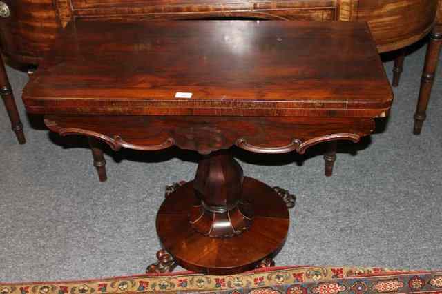 Appraisal: A VICTORIAN ROSEWOOD CARD TABLE with rectangular swivel top on