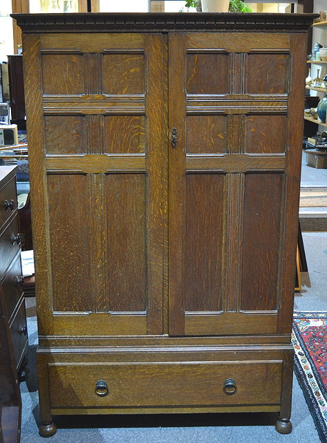 Appraisal: A Heals oak wardrobecirca model no C with panelled doors