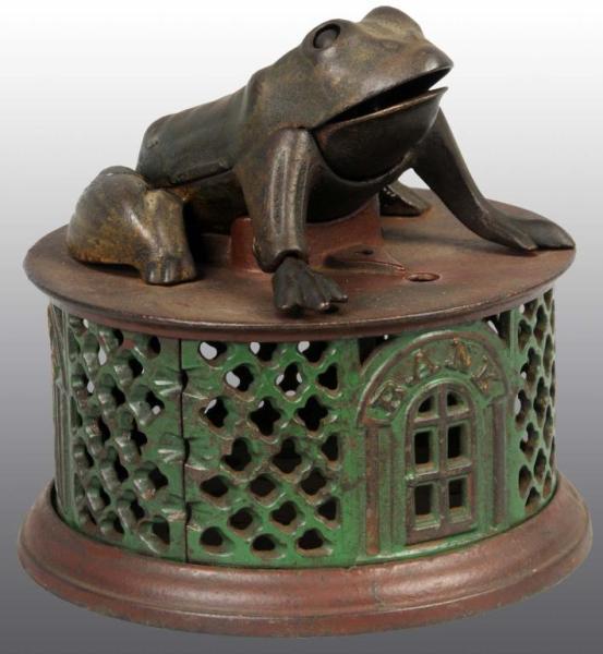 Appraisal: Cast Iron Frog on Lattice Mechanical Bank Description Manufactured by