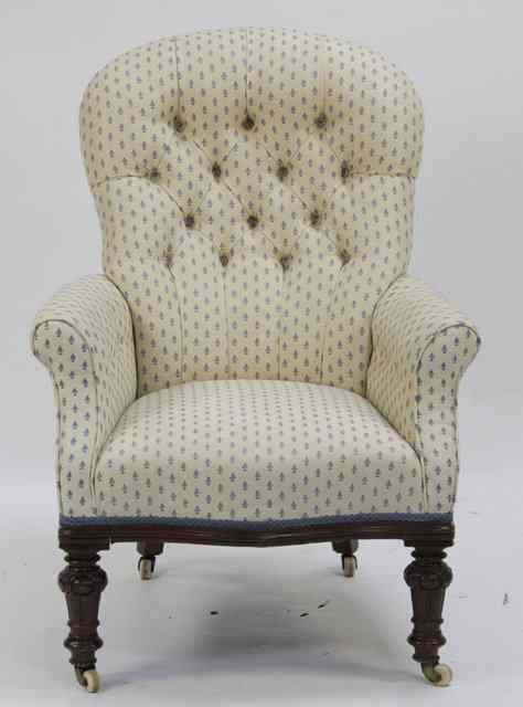 Appraisal: A Victorian upholstered armchair with deep button back on carved