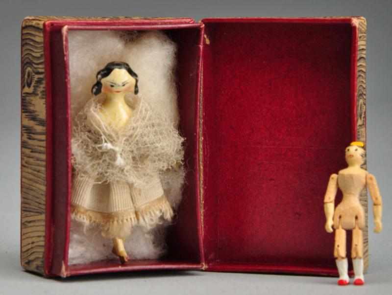 Appraisal: Two Tiny Peg Wood Dolls in Box Description Antique all