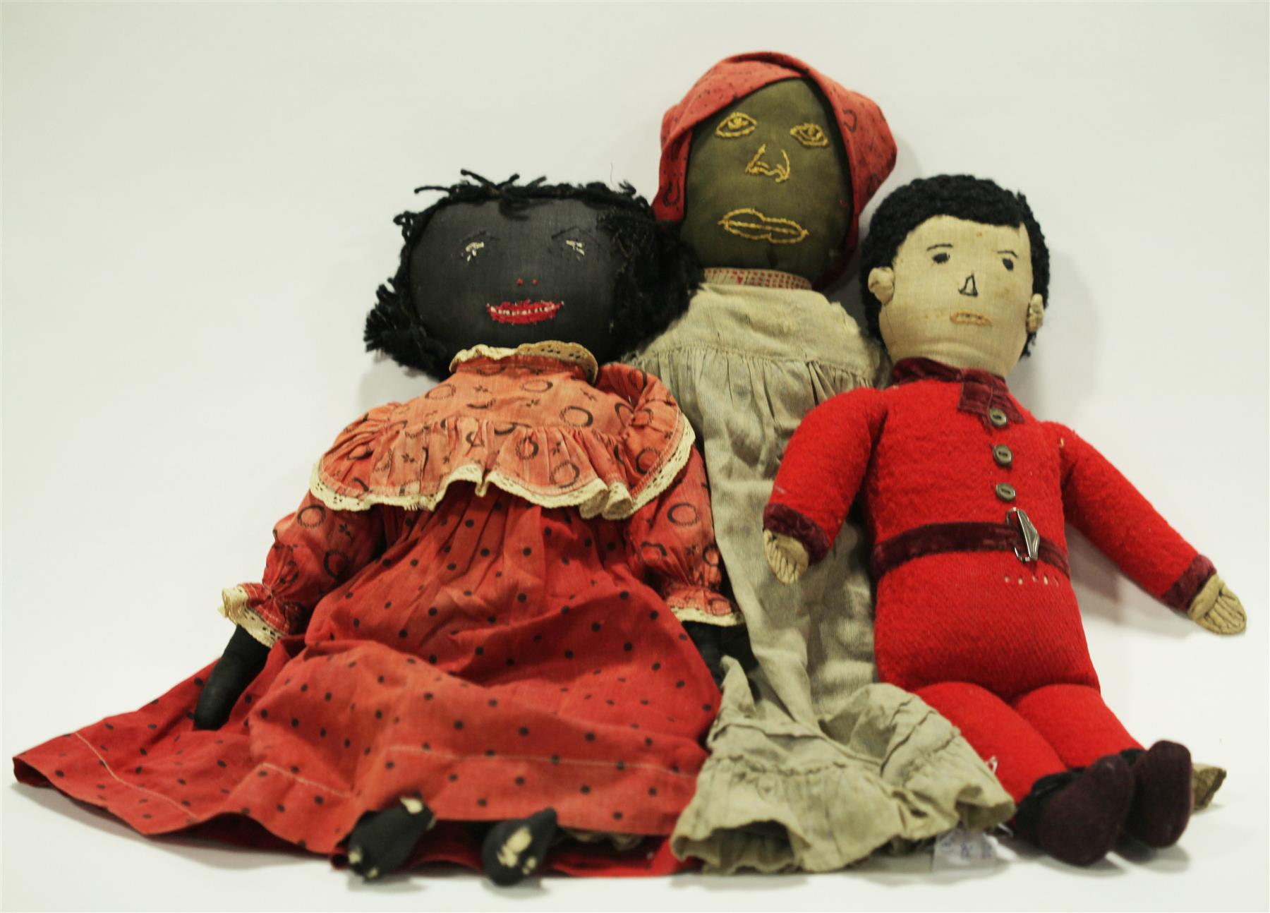 Appraisal: THREE BLACK CLOTH DOLLS American early s Stitched faces two