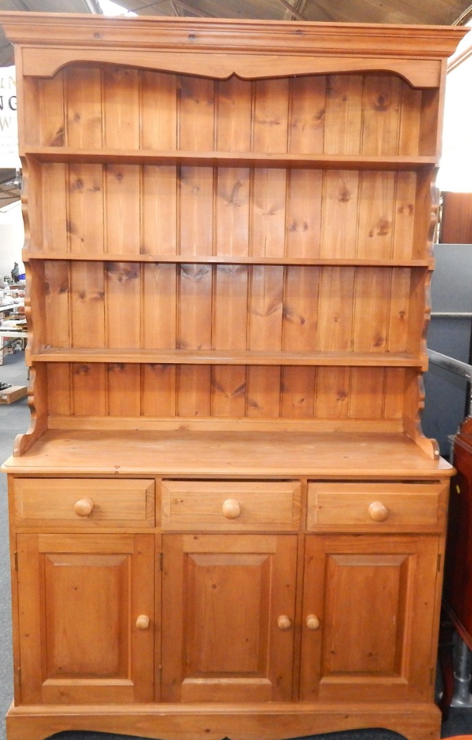 Appraisal: A pine dresser the outswept pediment above a three shelf