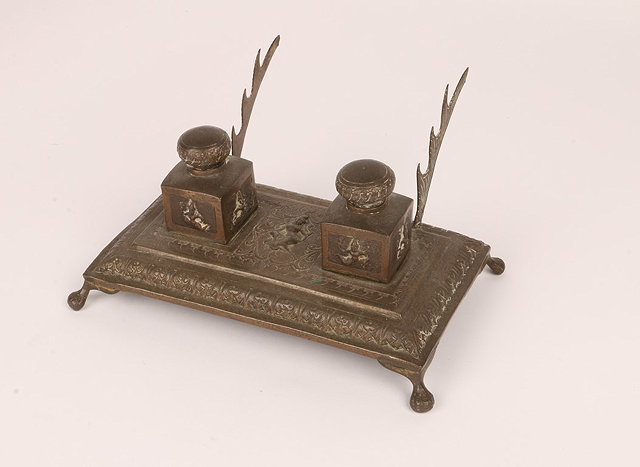 Appraisal: AN INDIAN SILVER COLOURED METAL DESK STAND with twin inkwells