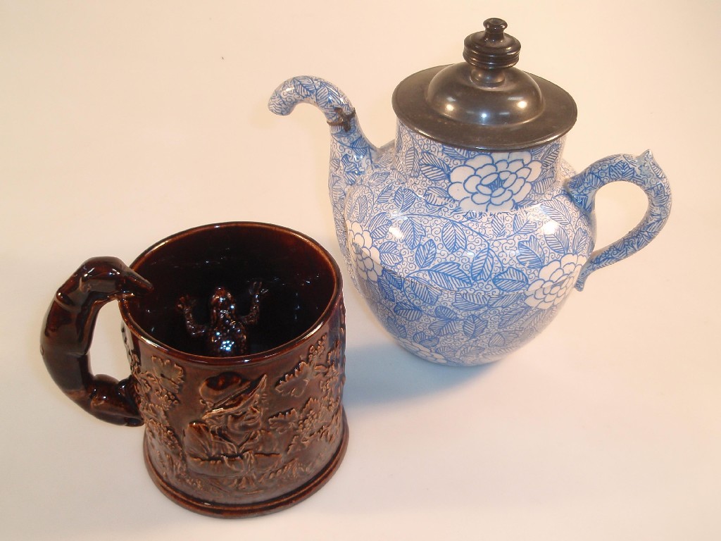 Appraisal: A treacle glaze frog mug moulded in relief with topers