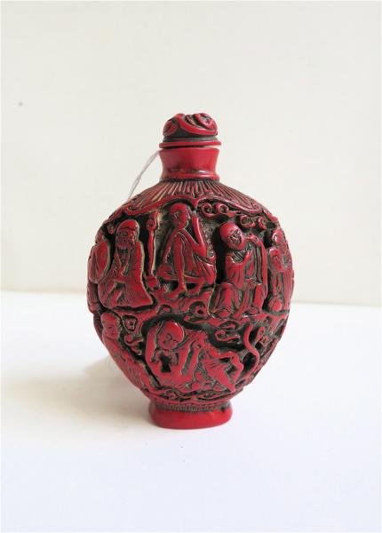 Appraisal: CHINESE CINNABAR SNUFF BOTTLE Qing Dynasty having carved Lohan figures