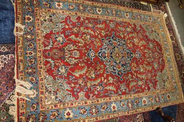 Appraisal: A PERSIAN RED GROUND RUG with foliate designs within a