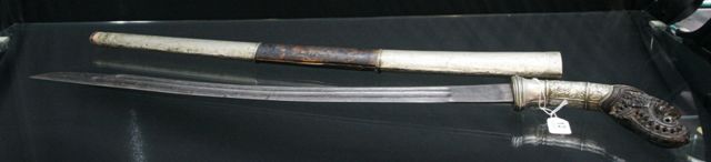 Appraisal: An Indonesian Klewang with carved horn hilt and Damascus blade