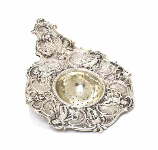 Appraisal: A German Silver Tea Strainer Hanau with putti and scrolling