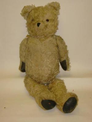 Appraisal: A mid th century teddy bear covered in pale gold