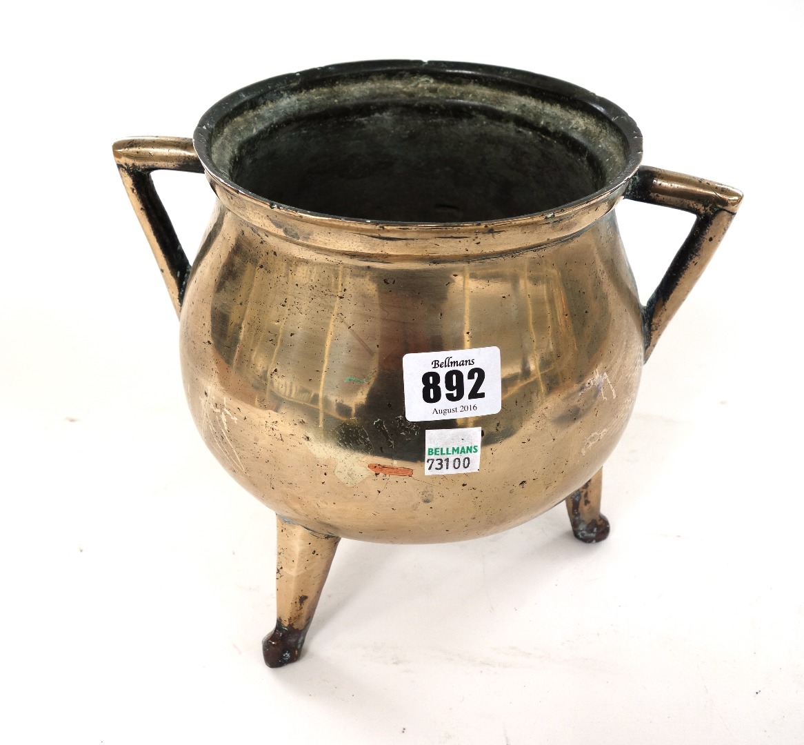 Appraisal: A two handled bronze cauldron on three feet probably th