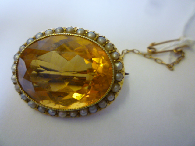 Appraisal: A CITRINE BROOCH the oval faceted stone within a border