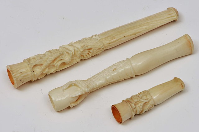 Appraisal: THREE CARVED IVORY CIGARETTE CHEROOT HOLDERS